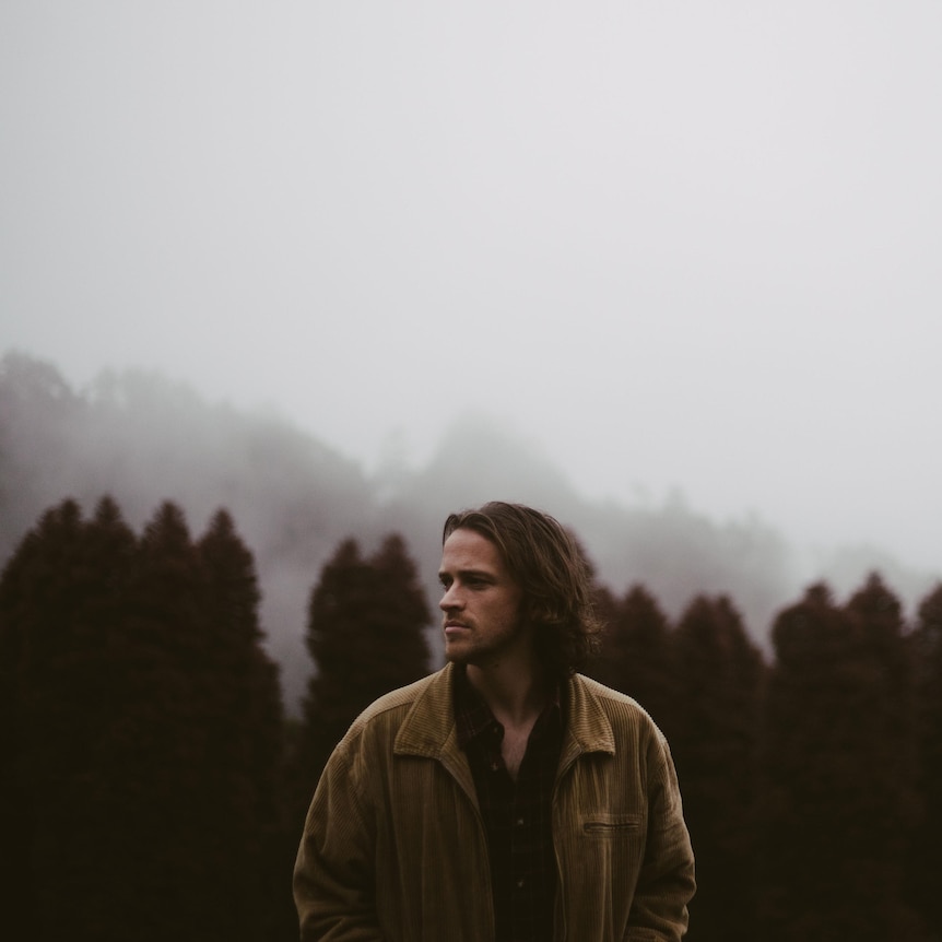 Image of musician Riley Catherall standing in the wilderness