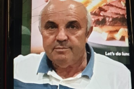 An older man with a bald head, wearing a T-shirt.