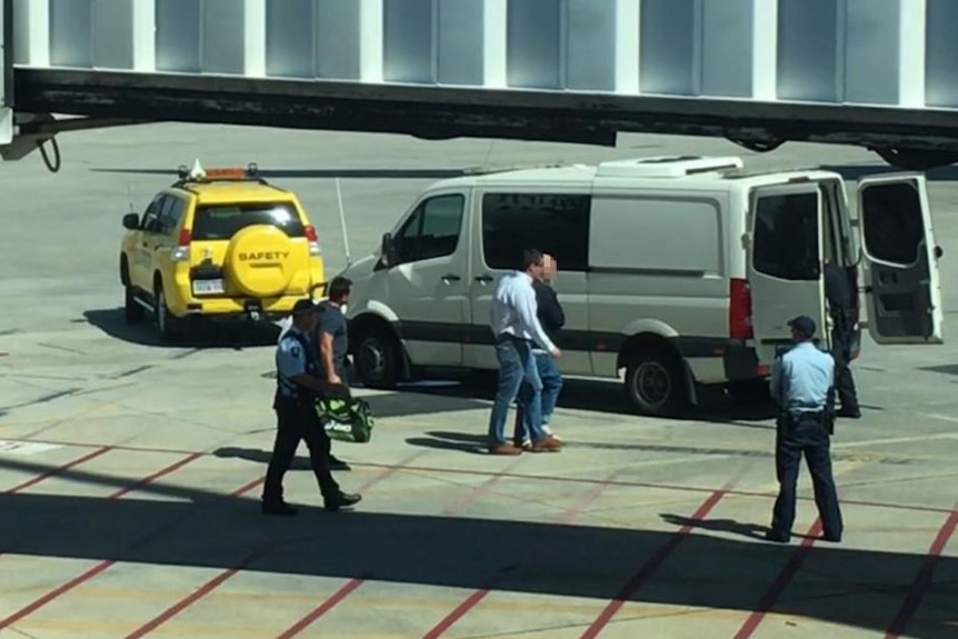 Francis John Wark walks across tarmac at Perth airport towards a waiting white van.