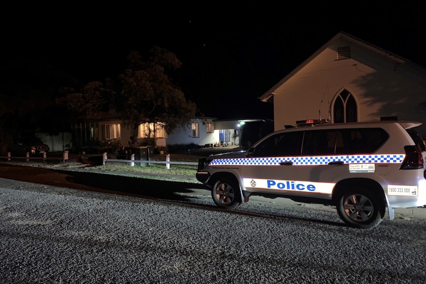 A police vehicle outside a house at night.