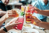 People holding up alcoholic cocktails