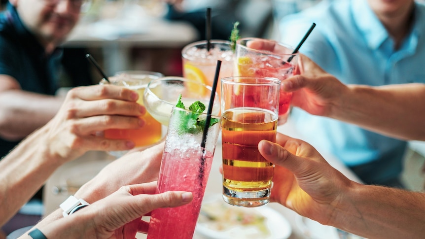 People holding up alcoholic cocktails