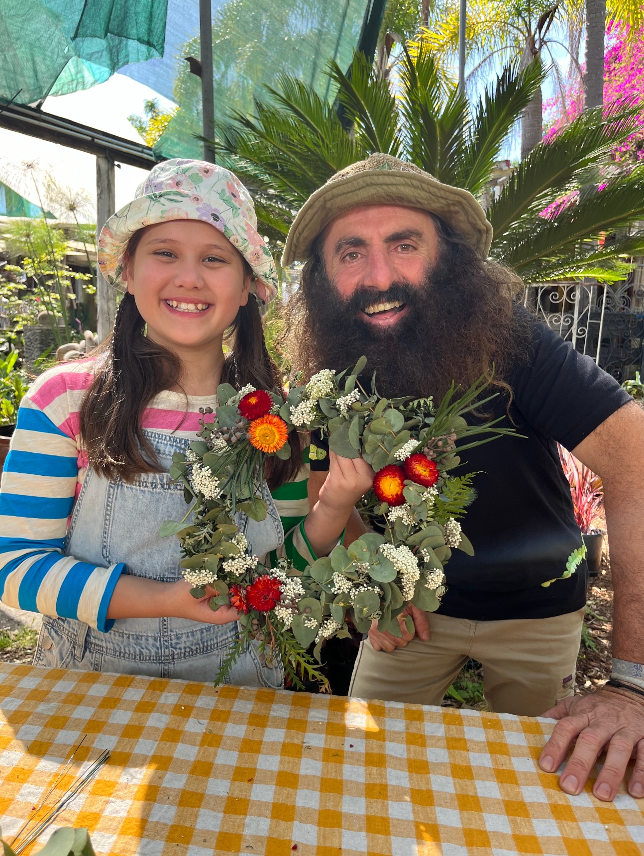 Costa and Millie hold up Wreath