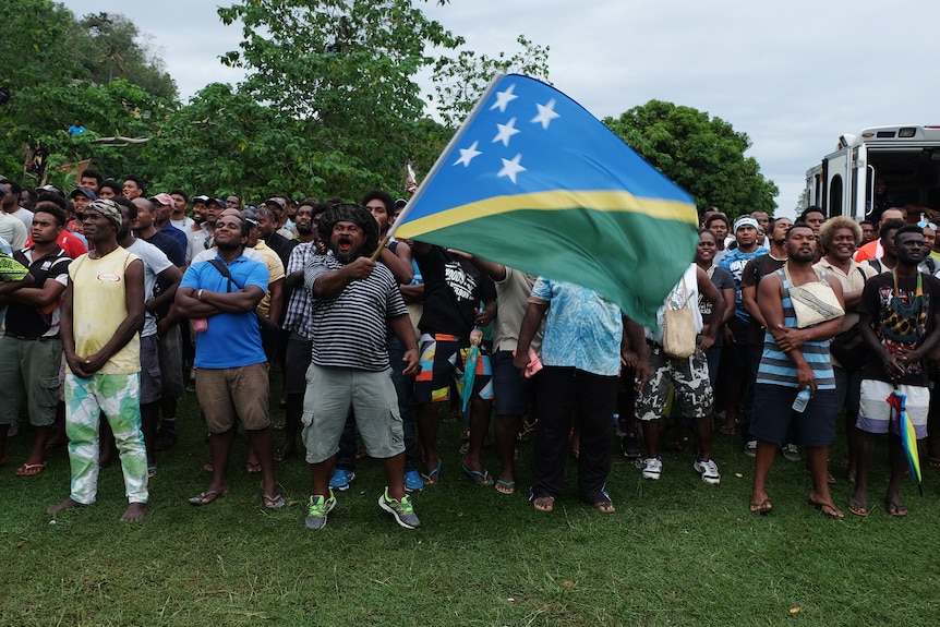 A man waving a Solomons flag