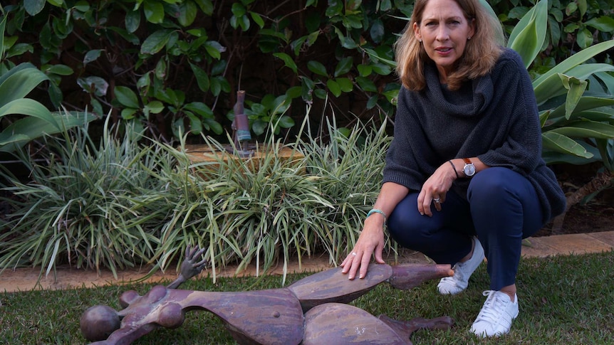 Carolyn Stewart in her garden with the returned sculpture.
