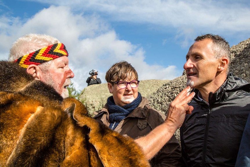 Australian Greens leader Richard Di Natale has ochre painted on his face.