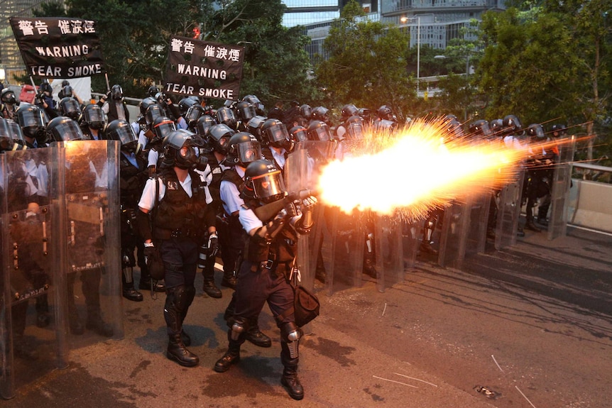 Agenti di polizia sparano gas lacrimogeni durante una manifestazione contro la proposta di legge sull'estradizione di Hong Kong.