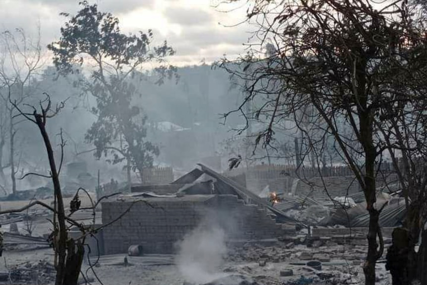 Smoke rises from smoldering houses.