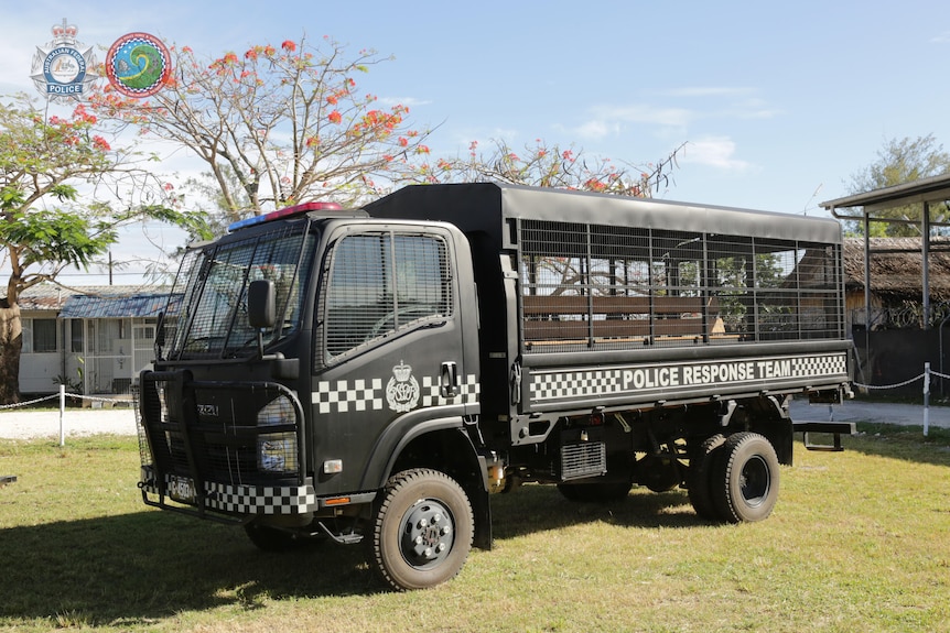 Un camion de police noir garé.