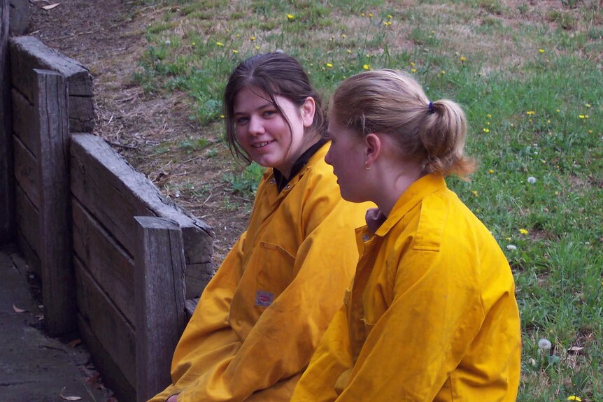Two teenaged girls in yellow jumpsuits
