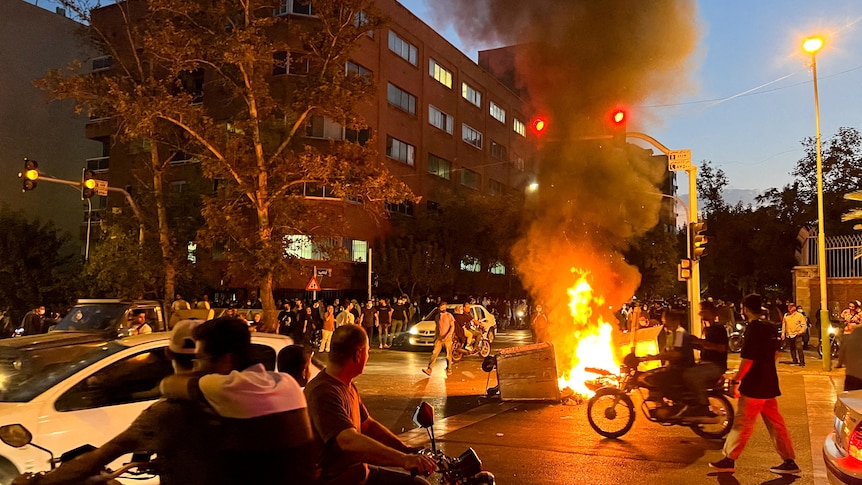 A police motorcycle burns during a protest over the death of Mahsa Amini in Iran.