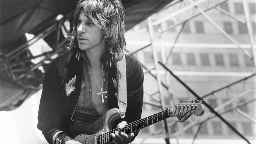 Black and white photo of Jeff Beck playing guitar on stage