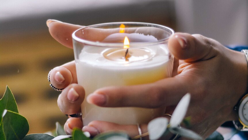 Hands holding a candle - what does living with COVID mean for the spiritual life?