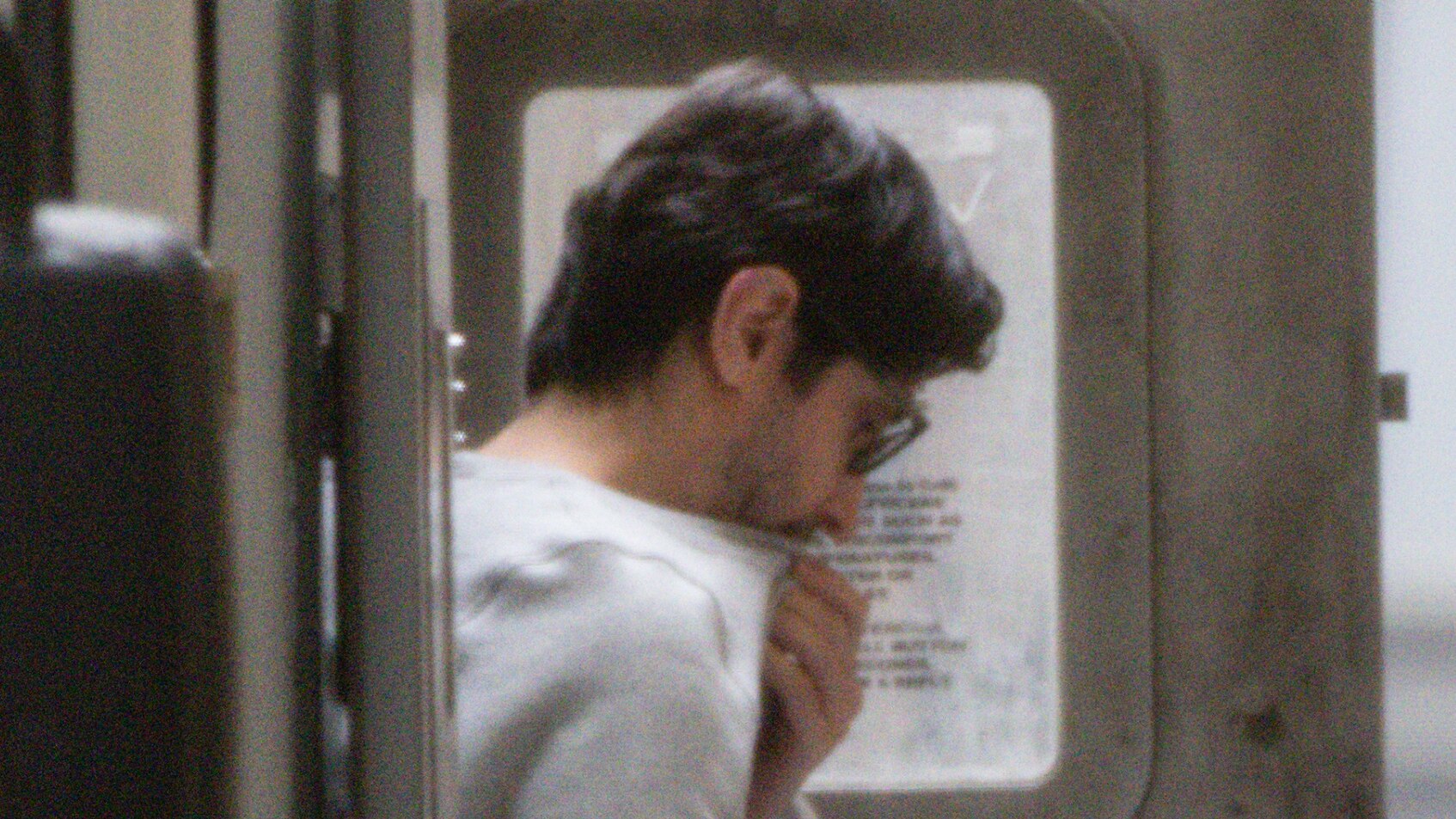 Luay Sako leaves a prison van, dressed in grey clothing.