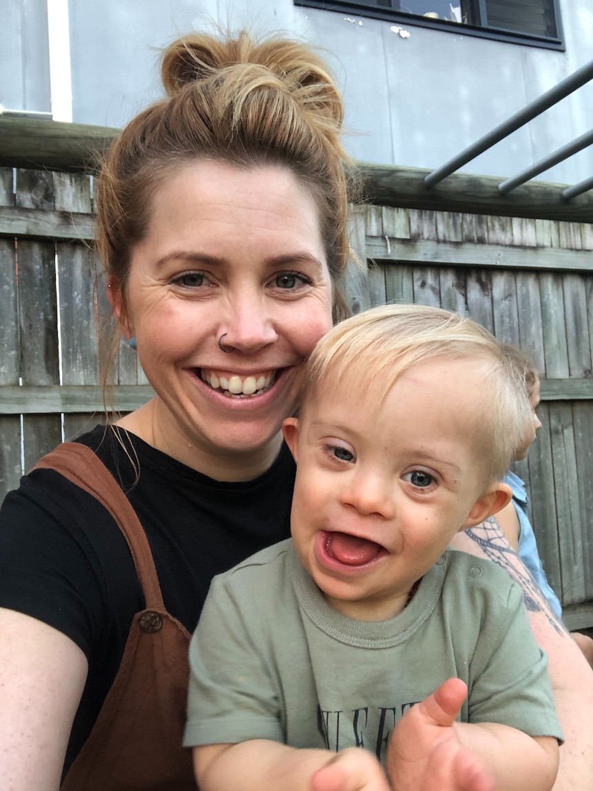 Young woman Julia Laine and her toddler Grayson smile warmly in a self portrait.