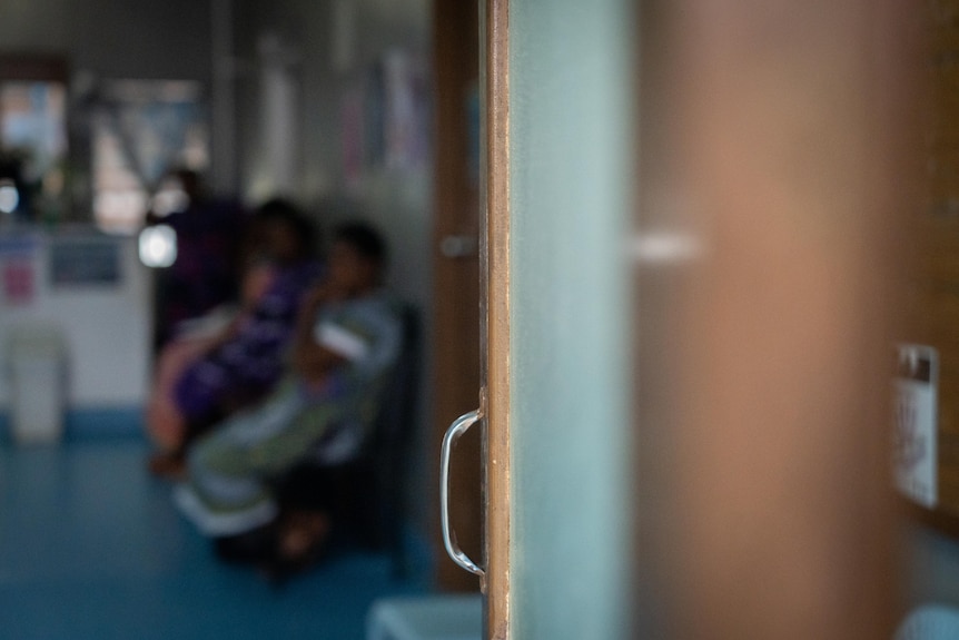 A blurred out photo of patients sitting in a health clinic.
