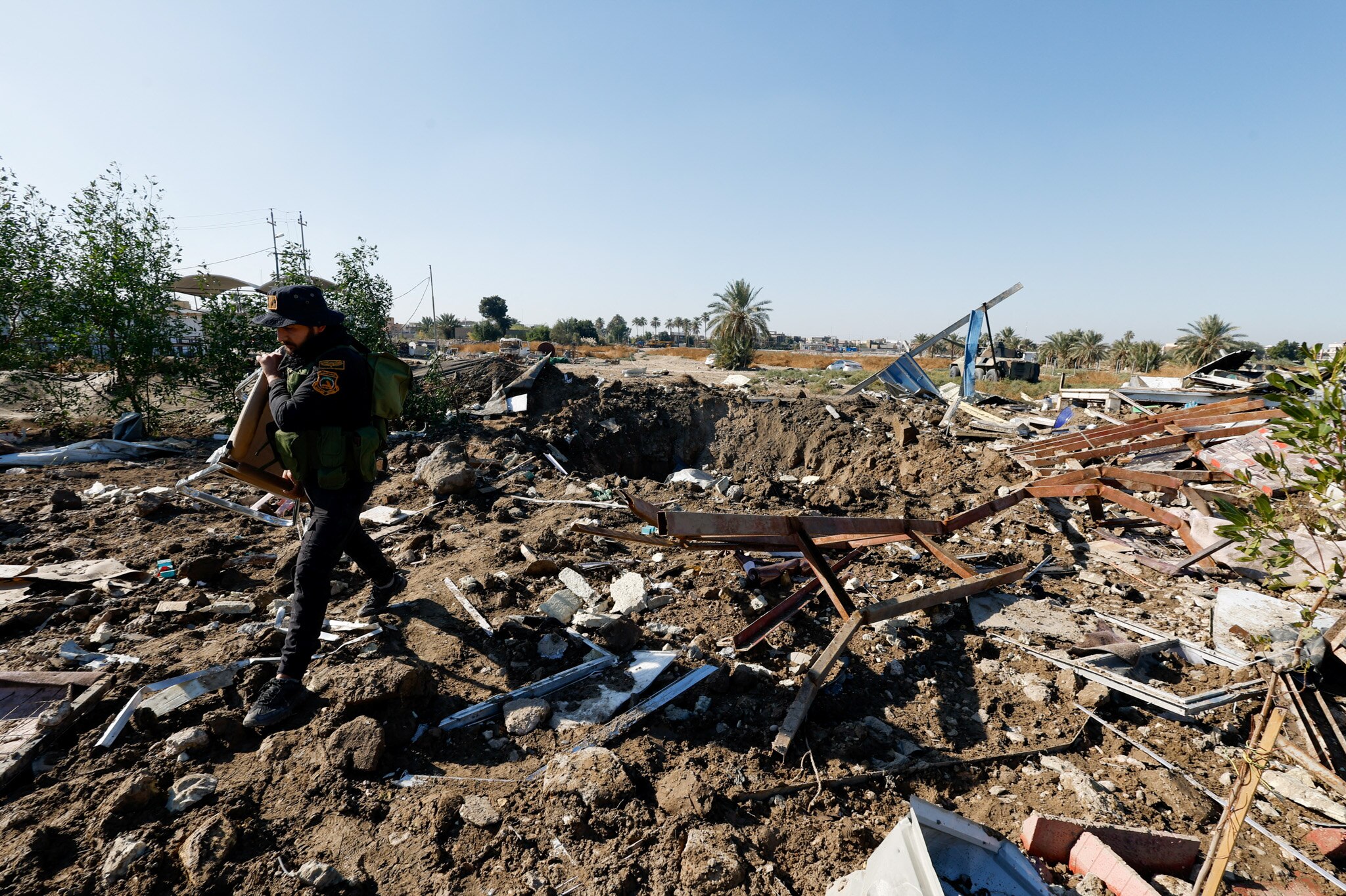 Debris from damaged buildings litters the ground as a man walks by.