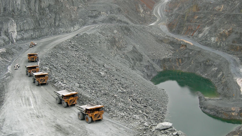Trucks drive into the Grange Resources mining pit at Savage River, Tasmania