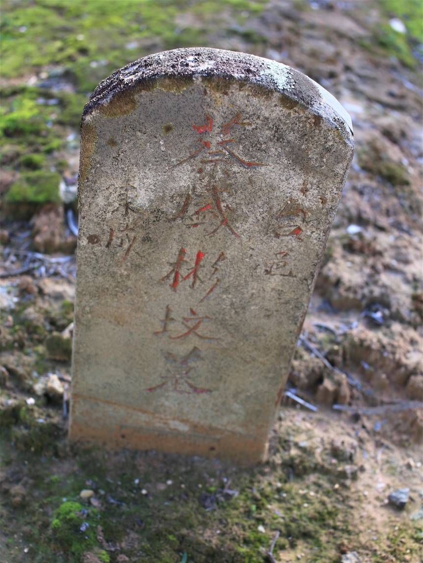 A grey tombstone with chinese inscription. 