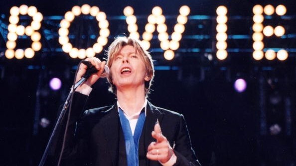 David Bowie performs in front of his illuminated name