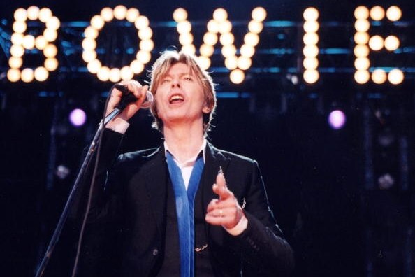David Bowie performs in front of his illuminated name