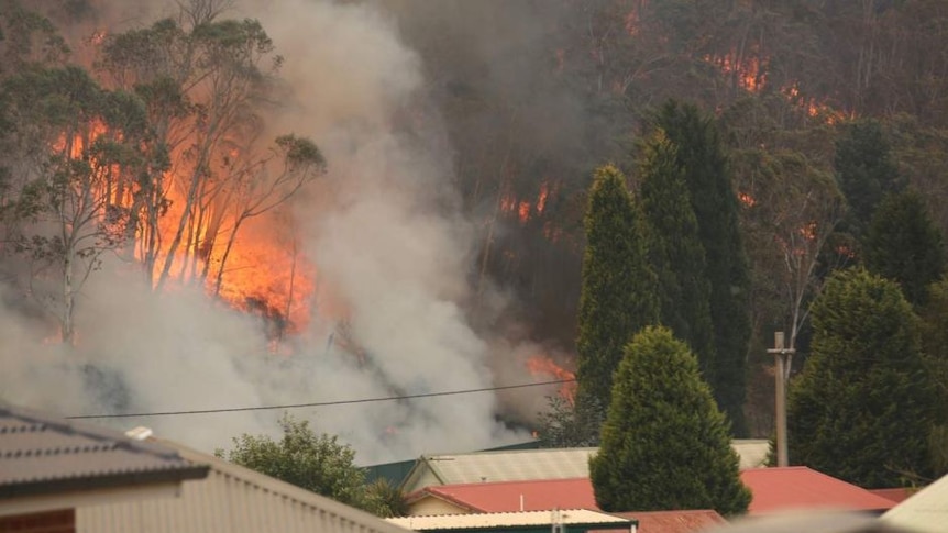 A bushfire rages near a home