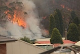 A bushfire rages near a home