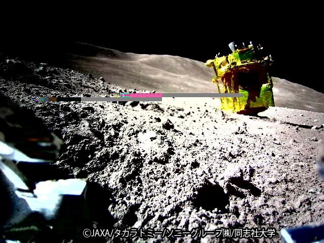 A yellow spacecraft with a pink line at the end of it surrounded by a bunch of space rocks on the moon.