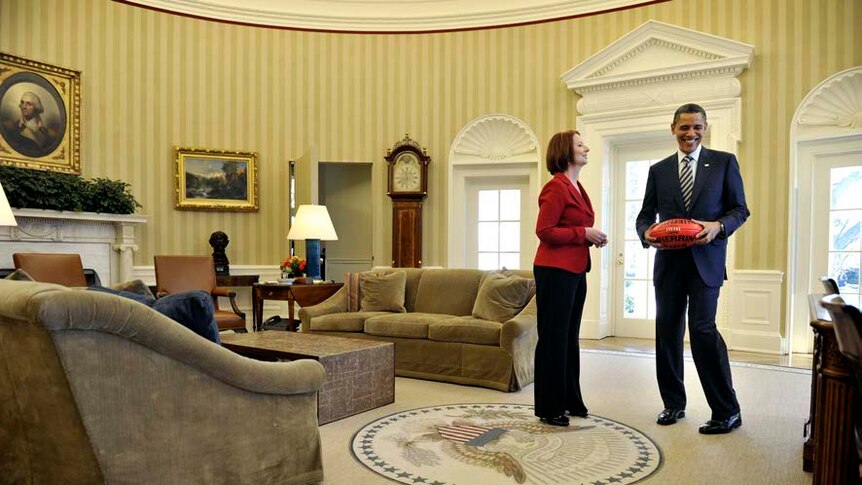 Julia Gillard shows Barack Obama an Australian Rules football in the Oval Office.
