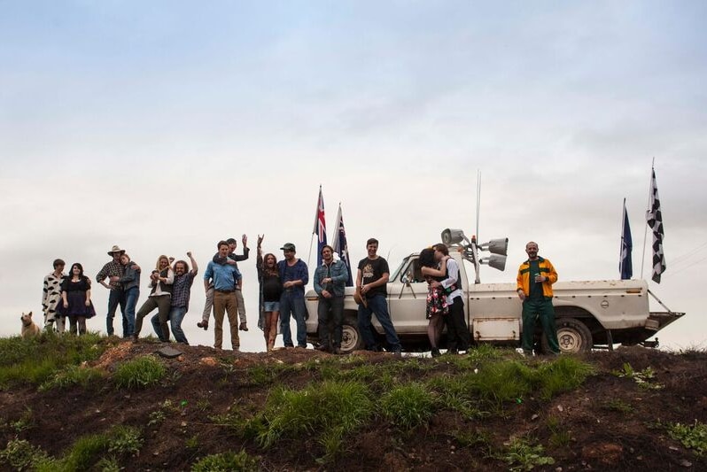 Image of people standing on a hill with a ute from a scene in the Australian film Spin Out