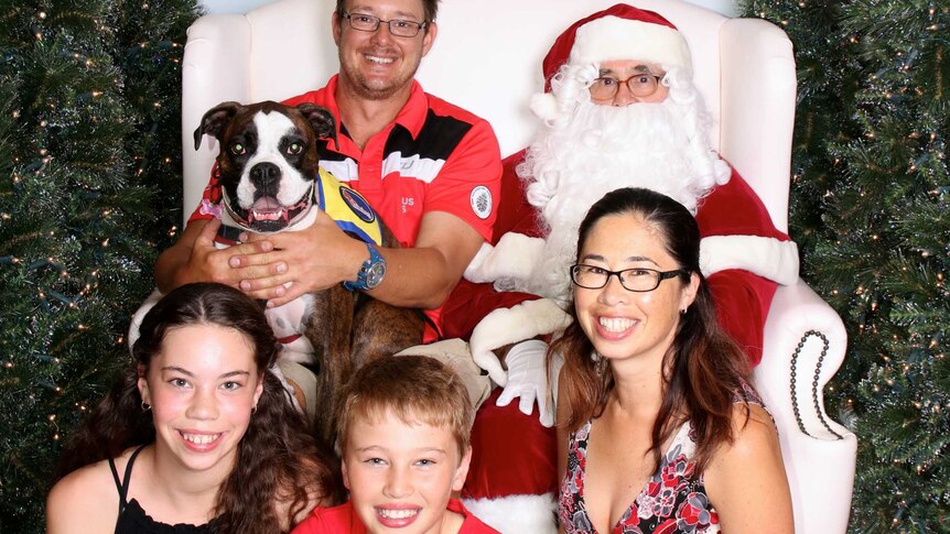 Smiling family with dog and santa