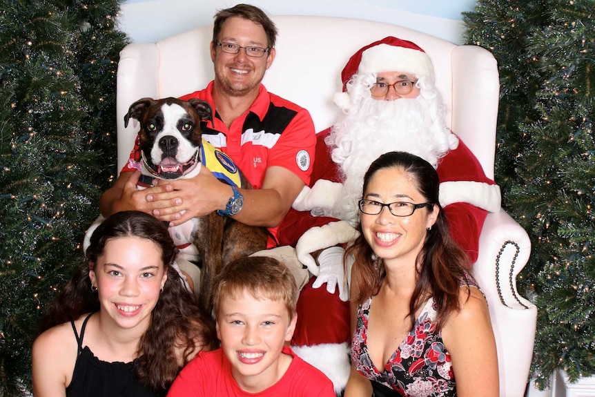 Smiling family with dog and santa