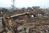 Residents walk in the rubble of destroyed houses.