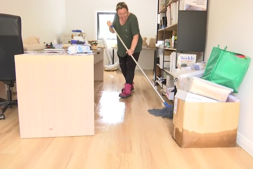 A lady mops up an office.