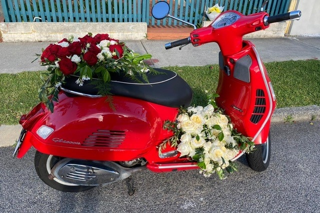 Flowers placed on a red scooter 