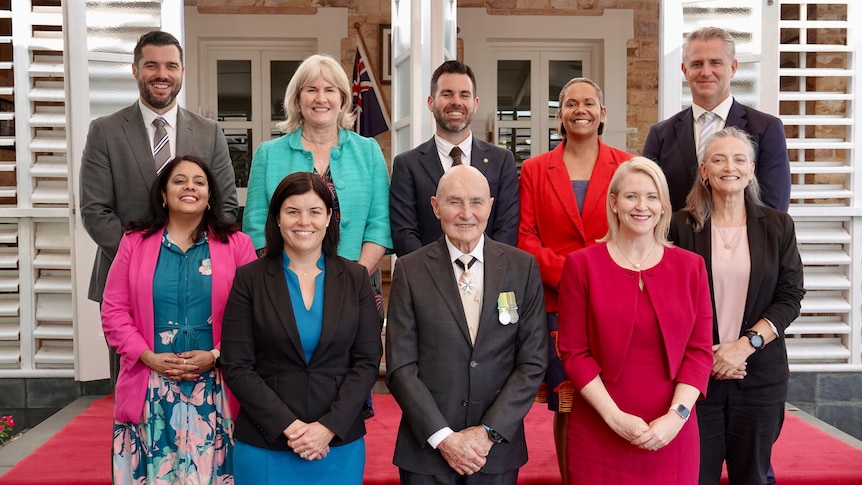 Members of the new NT cabinet and NT Administrator Hugh Heggie standing and smiling outside Government House.