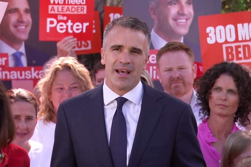 Peter Malinauskas surrounded by party members and signs with his face on them
