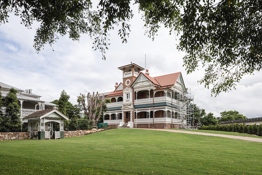A wide landscape view of the historic mansion after its restoration. Well manicured grass surrounds it.