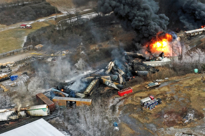 A view from above showing carriages off the track and flames. 