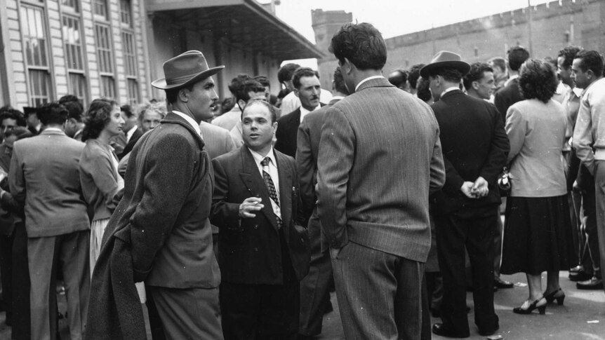 Black and white. Group of  Italian men and women standing outside talking