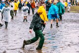 A muddy punter kicking a splash at Splendour In The Grass 2022