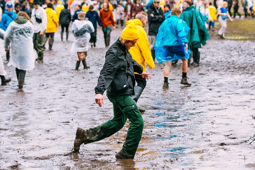 A muddy punter kicking a splash at Splendour In The Grass 2022