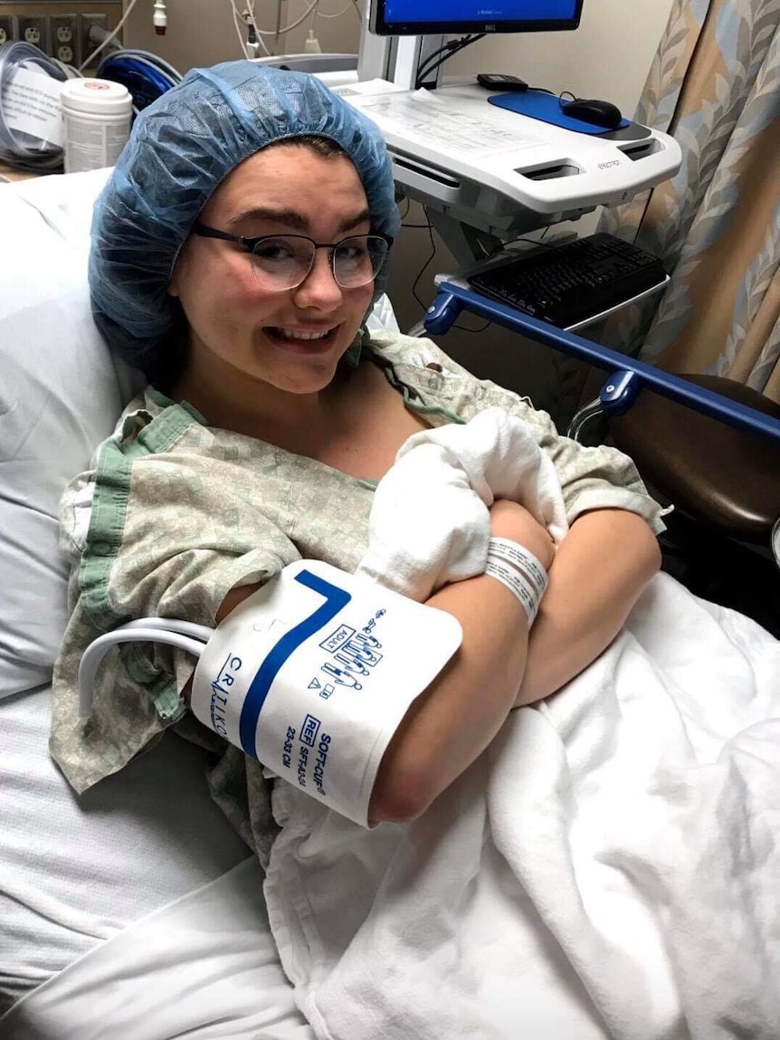 A young girl in a hospital bed smiling