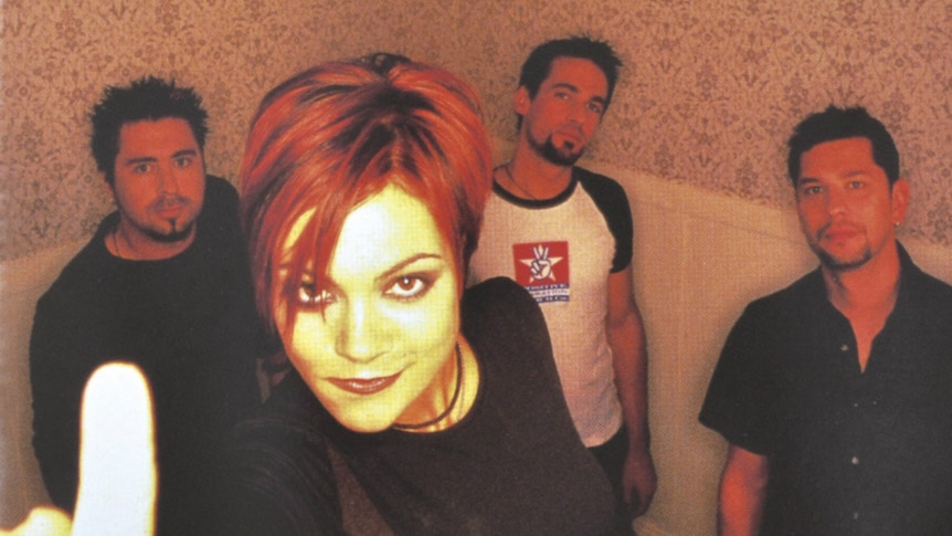 All four members of The Superjesus standing in a line with Sarah McLeod in the foreground pointing at the camera