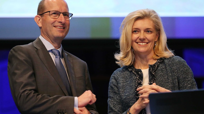 AMP CEO Craig Meller stands on stage with chairman Catherine Brenner.