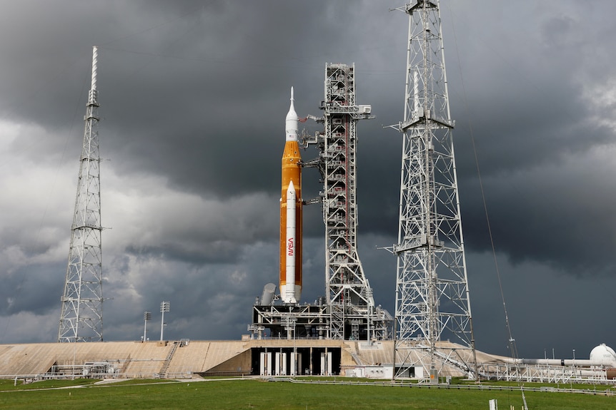 NASA moon rocket at launch station on a cloudy day.