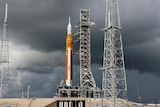 NASA moon rocket at launch station on a cloudy day.