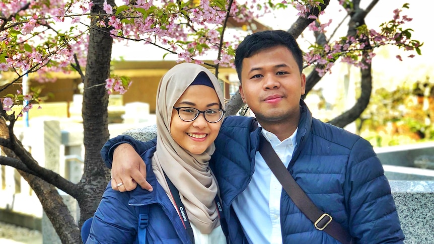 A woman and a man smile and pose together for a photo