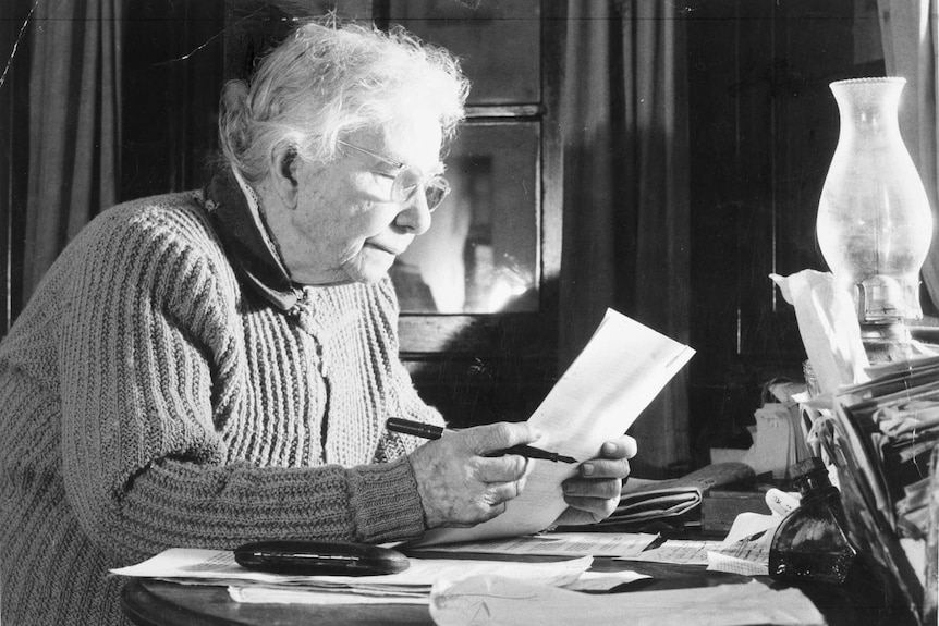 Black and white photo of Australian writer Dame Mary Gilmore at her desk.