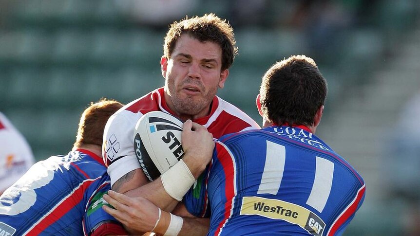 Desperation defence: The Knights keep Adam Cuthbertson at bay in Wollongong.